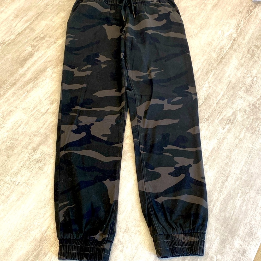 Black camo pants. New. No tags. 2 side pockets. Elastic at ankles. 1 pocket back
